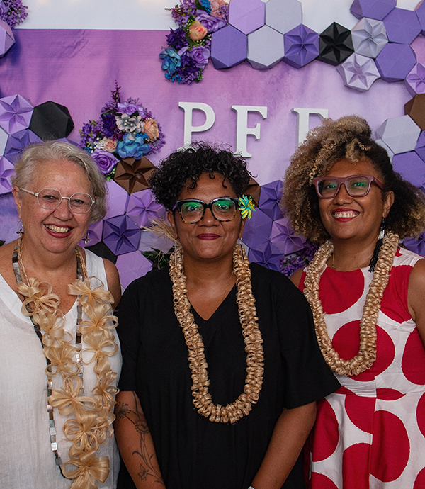 Three smiling woman standing.